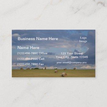 round bales in a field by silo. business card